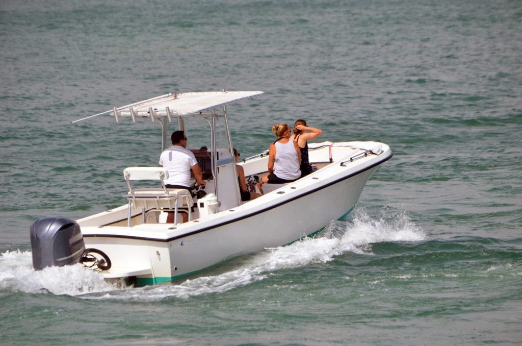 white open fishing boat powered by one outboard engine cruising on Biscayne Bay off of Miami Beach,Florida