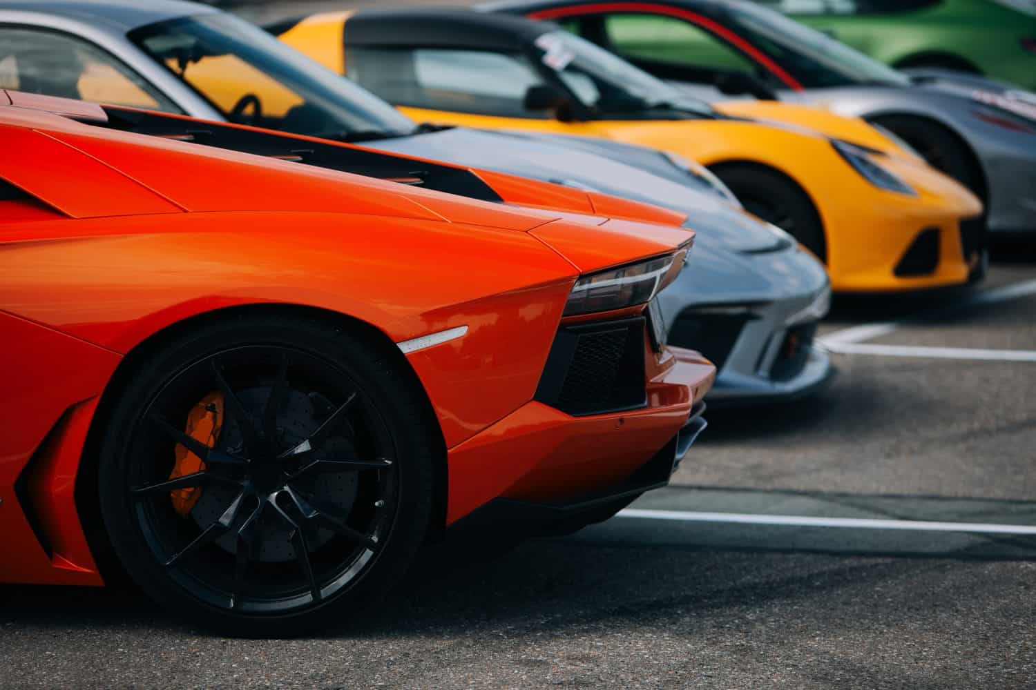 Exotic supercars assembled at the parking lot on a race track event. Track day preparation with sports cars ready for high-speed performance