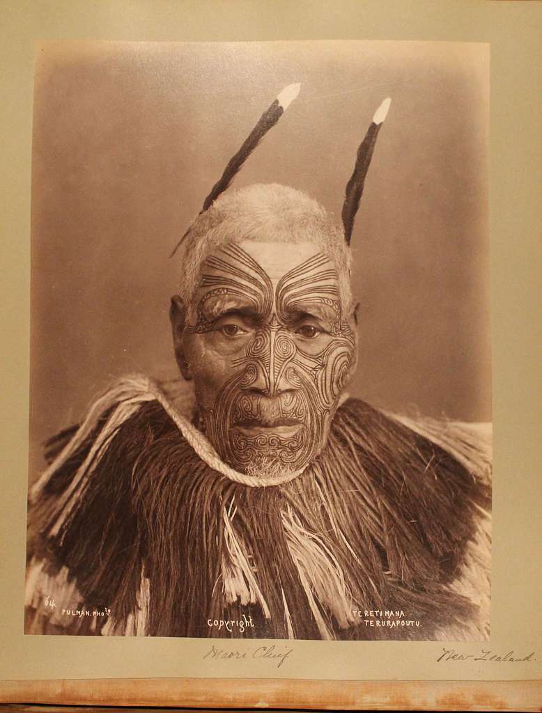 Maori chief, Teretimana Terurapoutu, poses against a plain background with feathers.