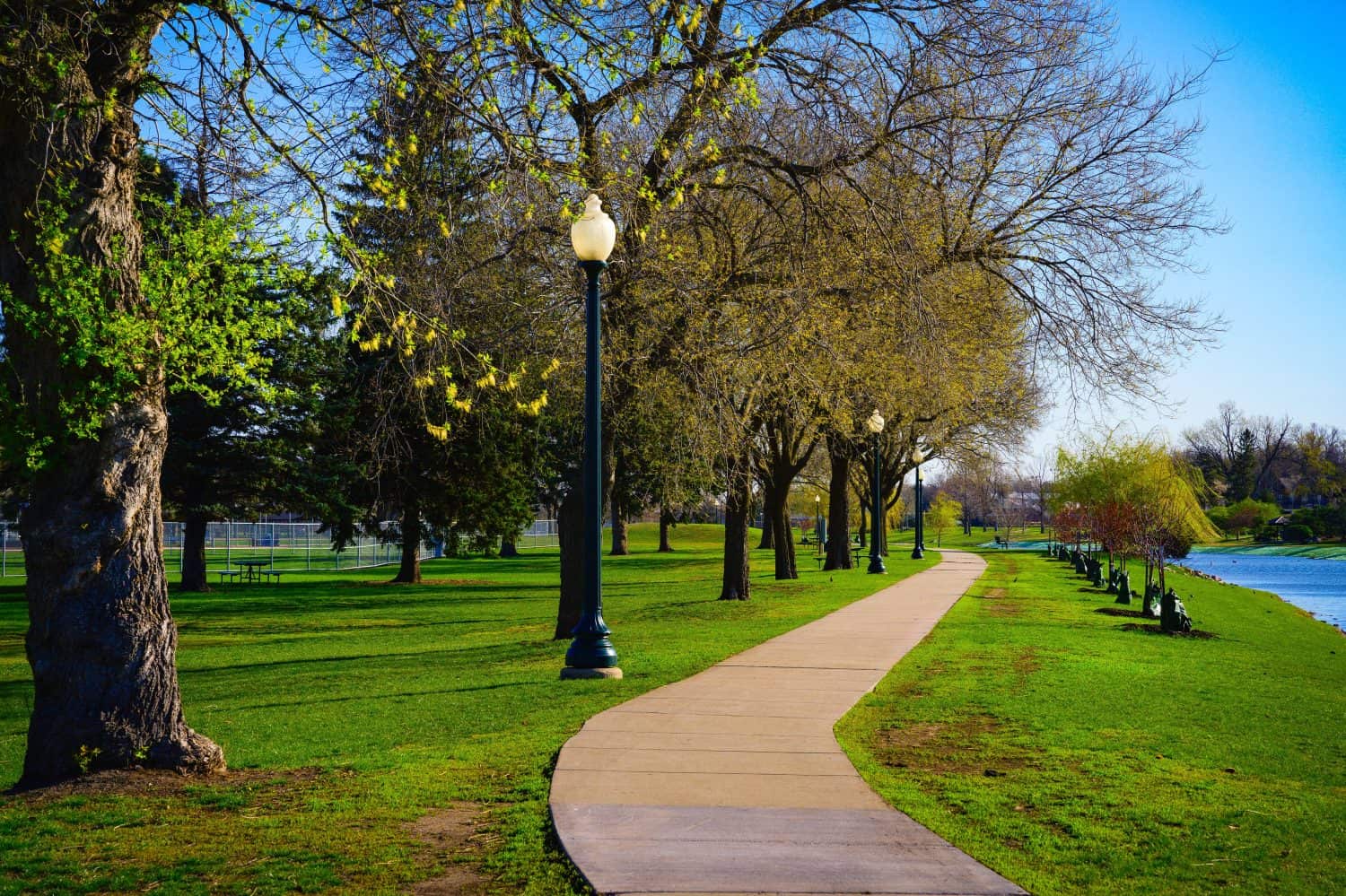 Tranquil spring forest walking trail landscape along the Covell Lake in Sioux Falls, South Dakota, USA