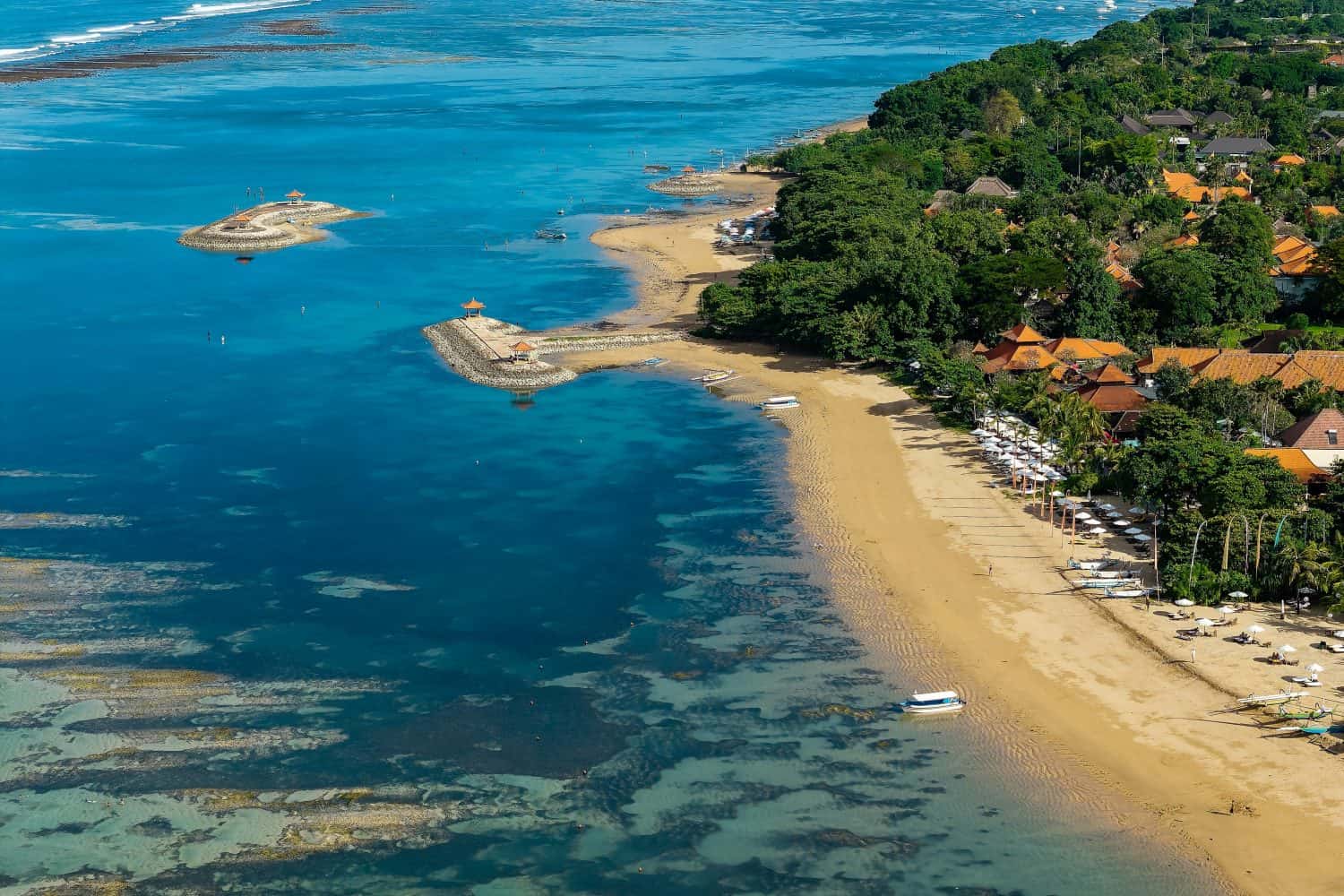 Aerial view of the coastline at Sanur Beach with resorts and calm water in Bali